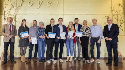 Gedeputeerden Maurits von Martels (l) en Gert-Harm ten Bolscher (r) met de winnaars van de Waarde-Ring 2024