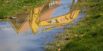 weerspiegeling van een dak en kraan in het water